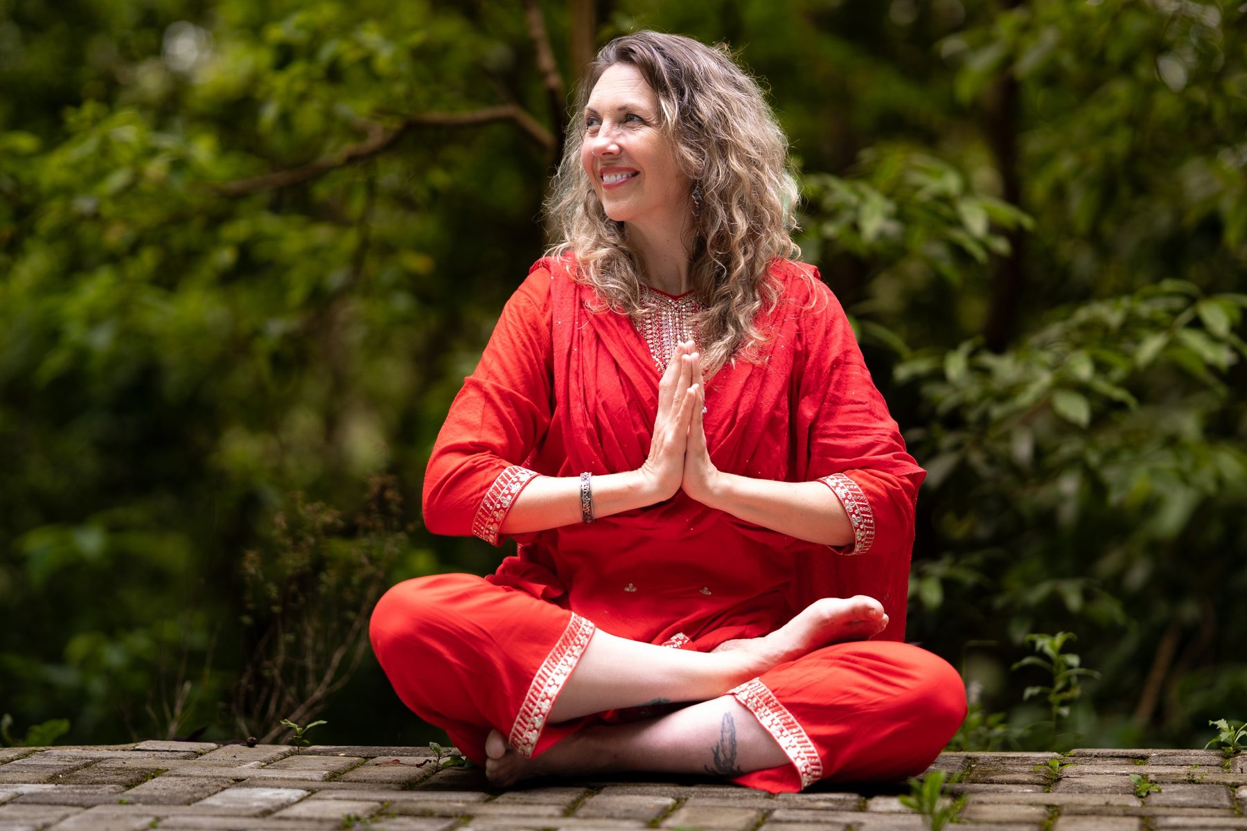 Dr. Jill Jyoti Satnam seated in meditation with hands in anjali mudra.
